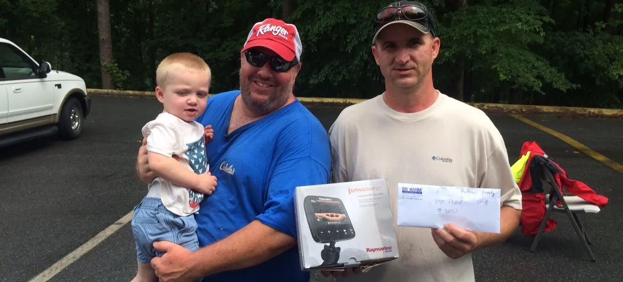 Tournament Winners - Men holding a child and certificate